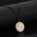 Macro detail of a vintage round pendant necklace with a gold frame on a sleek black cord. - Necklace / Black