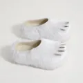 Detailed view of white faux fur claw slippers with metallic spikes and platform sole - White