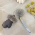 Detailed macro view of a grey faux mink fur glove charm with a silver wrist strap - Gray