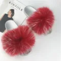 Detailed view of fashionable red raccoon fur slides with silver PVC soles and Kinfolk magazine - Red Base with White Tips