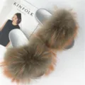High-resolution detail of fluffy raccoon fur slippers with metallic silver PVC soles. - Brown Base with Orange Tips