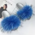 Close-up detail of silver PVC slides with lush blue raccoon fur trim - Lake Blue