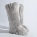 Vue détaillée de bottes de neige argentées en fausse fourrure de renard avec texture - Gris clair