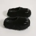 Close-up detail of black faux fur claw mule slippers featuring metallic spike design. - Black