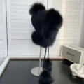 Vista detallada de un gorro de aviador de punto negro con lujosos pompones de piel de zorro - Talla única / Negro