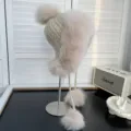 Vista detallada de un gorro de punto beige con orejeras de piel de zorro suaves. - Talla única / Rosa empolvado