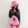 Detailed view of the pink faux fur bucket hat and matching hobo handbag on a model - Set / Hot Pink