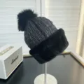 Detailed view showing the black winter hat with a large fox fur pom-pom and mink brim - One Size / Black