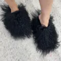 Close-up view of fluffy black Mongolian sheep fur slides worn on a textured rug. - 5 (Shoe Length 250, Inner Length 225) / Black