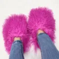 Detailed view of vibrant fuchsia Mongolian sheep fur slippers worn with blue jeans. - 5 (Shoe Length 250, Inner Length 225) / Rose Red