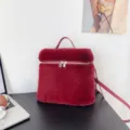 Red faux mink fur backpack and handbag with silver zipper and top handle in a cozy room - Burgundy