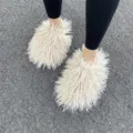 Close-up detail view of fluffy cream Mongolian faux fur slides being worn outdoors on asphalt - 40/41 / Beige