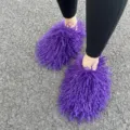 Detailopname van pluizige paarse Mongoolse imitatiebont slippers op buitenbestrating - Donkerpaars