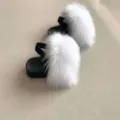 Detailed macro view of fluffy white faux fur kids sandals featuring a black elastic back strap - 4C / White
