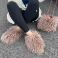 Gros plan sur des chaussons en fausse fourrure rose et un sac à bandoulière assorti - Ensemble couleur thé au lait