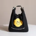 Elegante bolsa de almuerzo de lona negra con carita sonriente amarilla y cierre de hebilla - Negro