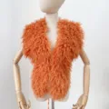 Detail van oranje gekruld imitatie Mongools bont haltervest op een houten pop - Eén maat / Oranje