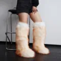 Close-up detail of fluffy Y2K faux fur knee-high snow boots in vibrant white and orange - White with Orange Tips