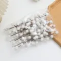 Detailed shot of white frosted artificial berries stems in a transparent bag for holiday decor. - Twelve-Fruit Glass Bead - White