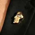 Artistic gold-tone half-face mask brooch featuring a heart-shaped blue stone eye - Blue Heart Rhinestone Mask (1718) / Gold