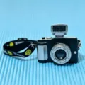 Close-up of a miniature black camera accessory with a yellow smiley face smile strap - Miniature Camera / 1 Piece/Pack / Black