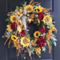 Detailed view of a French country style sunflower wreath with autumn leaves on a dark door. - 48cm / Colorful