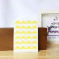 Detail des autocollants de coins photo jaunes proprement alignes pour albums et scrapbooking. - Jaune Citron