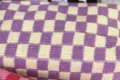 Strick Kosmetiktasche Detail, lila gelb kariert Strickstoff Textur Nahaufnahme Ansicht. - Lila