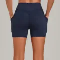 Women's high-waisted yoga shorts in dark blue, featuring side pockets and a peach-lifting contour. - S / Bottoms / Dark Blue Green