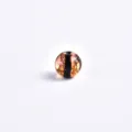 Close-up detail of a transparent glass bead with golden flakes and dark stripe for DIY jewelry. - Gold
