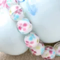 Close-up detail of handmade glass flower beads, colorful petal pattern inside clear beads. - 12mm / White