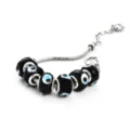 Silver snake chain charm bracelet featuring black evil eye glass beads and heart pendant. - C Black