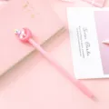 Detailed view of the cute pink unicorn gel pen with crescent moon topper on pink desk. - Pink