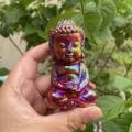 Aura crystal carved baby Buddha figurine, displaying brilliant iridescent colors detail. - Electroplated Red