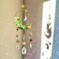Close-up view of a crystal suncatcher crescent moon with green stones and prisms. - Green Aventurine / Approx 41-43cm