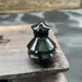 Close-up detail of the miniature polished black crystal Christmas tree stone carving. - Obsidian