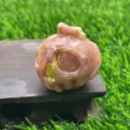 Close-up detail of the 3.5cm natural gemstone crystal ghost pumpkin carving home decor. - Plum Blossom Tourmaline