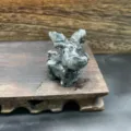 Detail shot of a natural stone elk animal crystal carving, showcasing fine craft and texture. - Black Labradorite