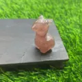 Detailopname van het schattige kristallen alpaca beeldje op een houten sokkel met fijne textuur. - Aardbeienkwarts