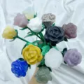 Primo piano dettagliato di un bouquet di rose in pietra preziosa intagliate con steli verdi. - Selezione Casuale (Ramo Argento)