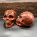 Detailed view of natural red stone carved skull figurine, crystal gemstone decor sculpture. - Sesame Jasper
