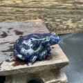 Gros plan detail de vue de sculpture de grenouille en cristal bleu sur support en bois. - Sodalite Bleue
