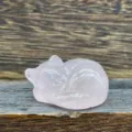 Gros plan détaillé d'une sculpture de chat endormi en cristal rose, surface polie, gemme. - Quartz rose