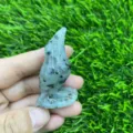 Close-up detail of the hand-carved gemstone raven bird sculpture, showing fine texture and markings. - Kiwi Jasper
