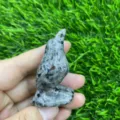 Close-up detail of hand-carved crystal raven bird figurine, natural gemstone mineral texture. - Flame Stone