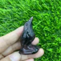 Detail view of a 5cm hand-carved crystal raven bird figurine, perfect for healing crystal decor. - Garnet