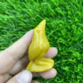 Handheld yellow gemstone carved raven crystal bird figurine detail view close up display - Golden Quartz / Citrine Color