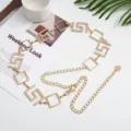 Elegante cadena de cintura de metal dorado con pedrería brillante y eslabones geométricos. - Dorado