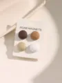 Gedetailleerde close-up van een set van vier aardekleurige magnetische hijabspelden op kaart. - Set van 4 Paar / Gele Serie