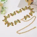 Close-up detail of retro metal waist chain with butterfly and turquoise stone elements for detail. - Antique Gold